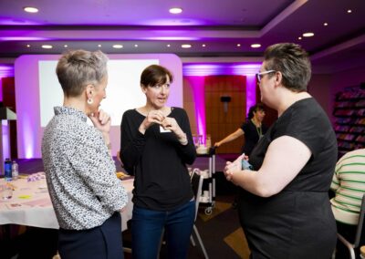 SENCOs discussing with Angharad Welch a speech and language therapist in front of the stage at SENsible24