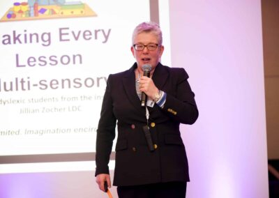 Dr Susie Nyman at SENsible24 SENCO Conference holding a microphone and introducing the multi-sensory lesson.